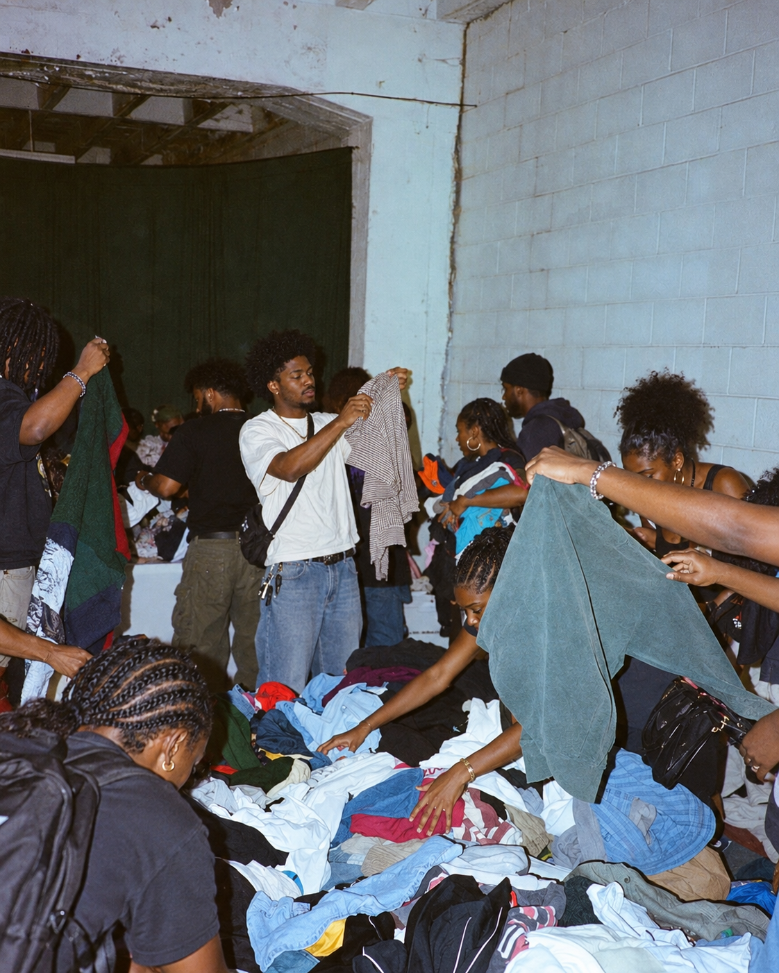 Black shoppers browsing clothing in a warehouse sale for Moneta University